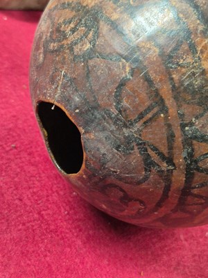 Lot 263 - A Guatemalan tribal gourd painted in black...