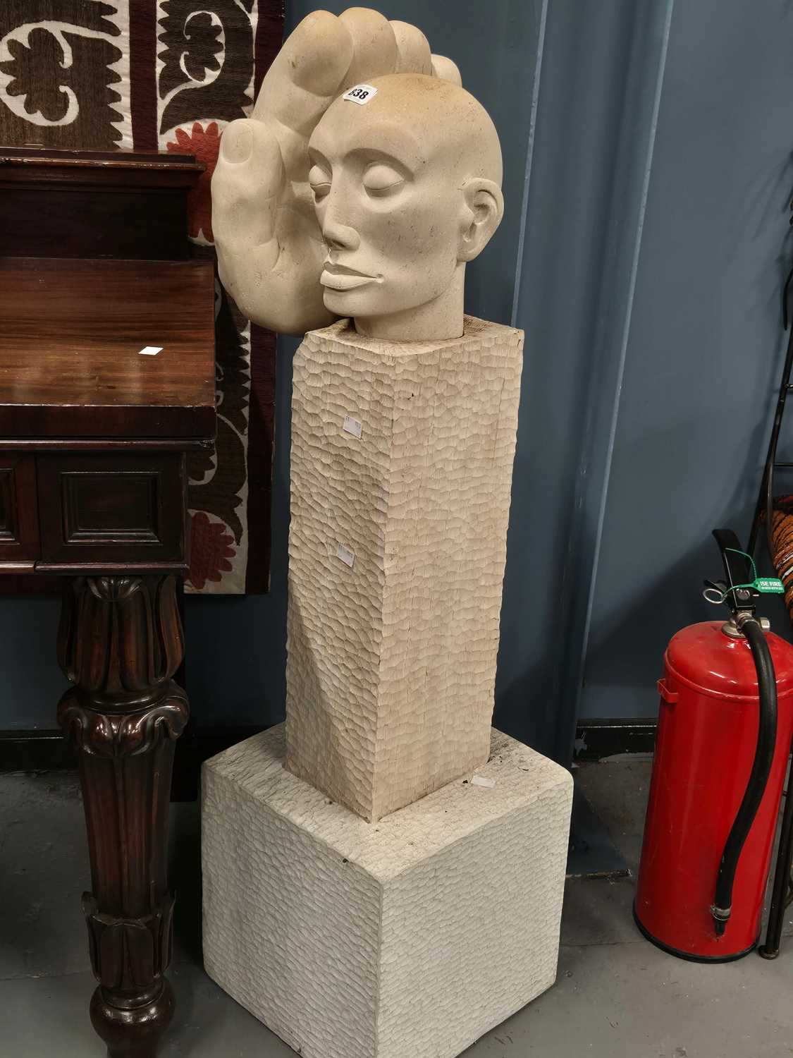 Lot 838 - A limestone sculpture on a chip carved wood...