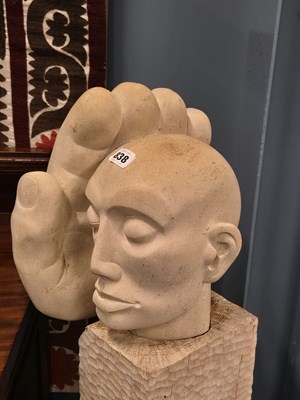 Lot 838 - A limestone sculpture on a chip carved wood...