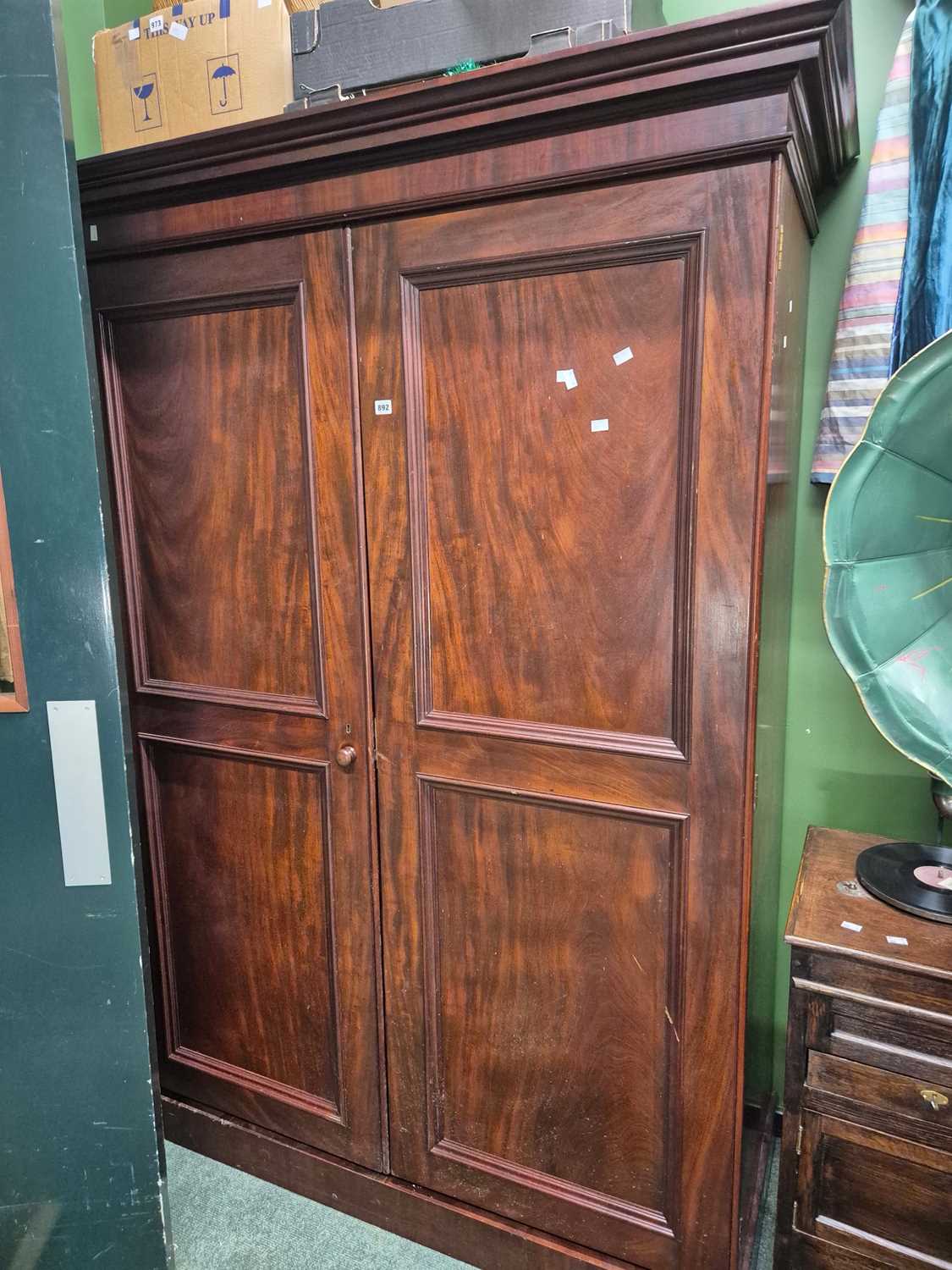 Lot 892 - A mahogany wardrobe, each door with two panels...