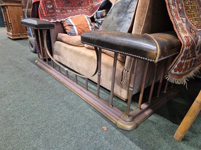 Lot 894 - A green leather seated brass club fender....
