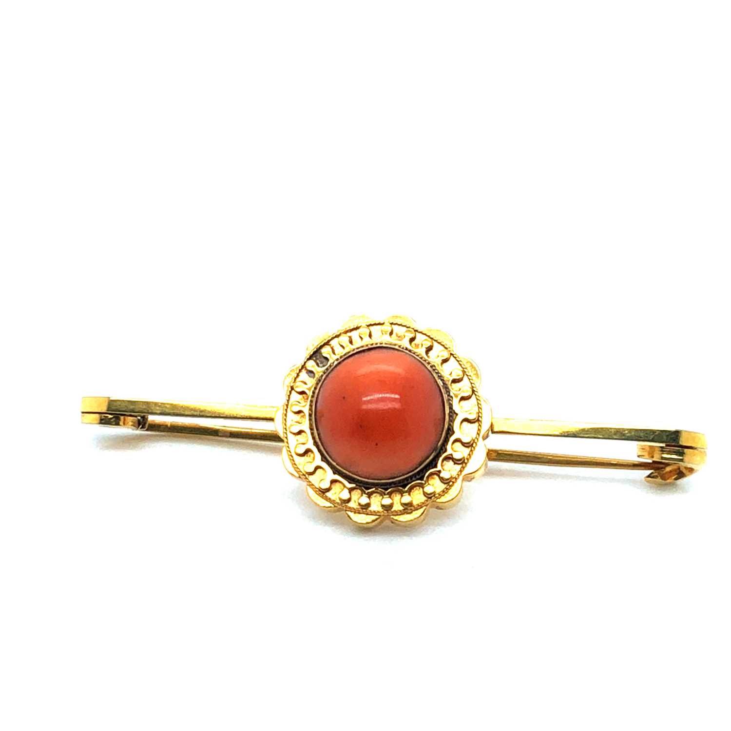 Lot 37 - An antique coral cabochon set bar brooch....
