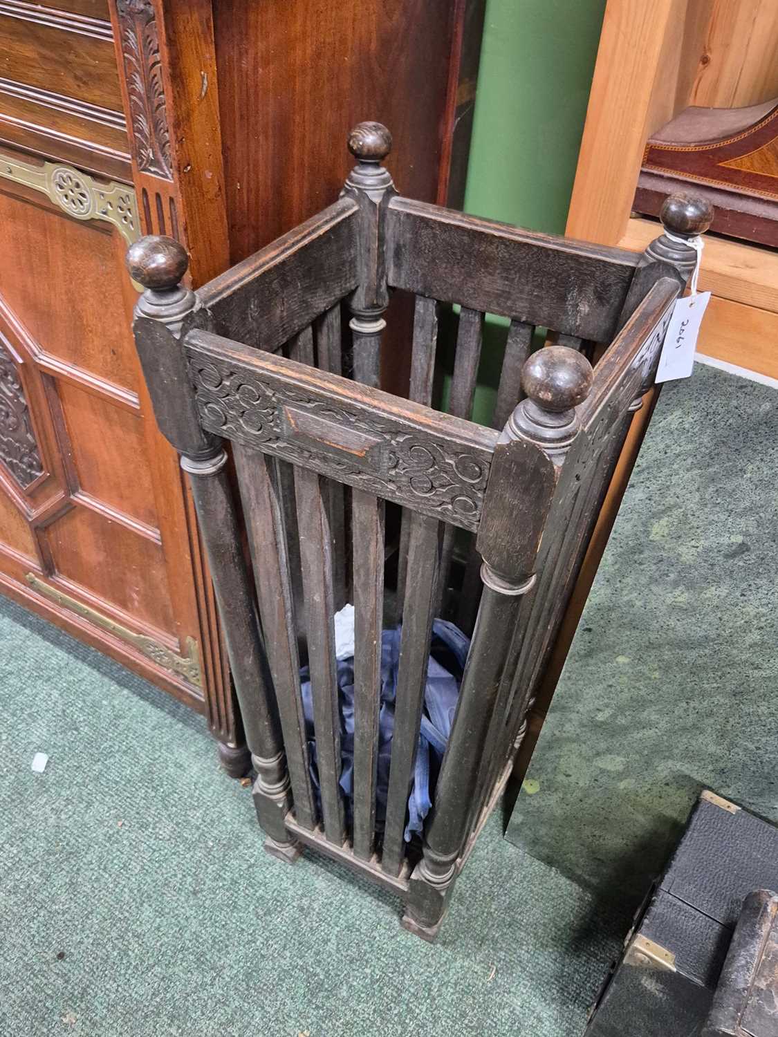 Lot 2061 - An oak strap sided stick stand, the square...
