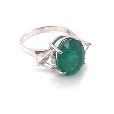 Lot 66 - An emerald and diamond ring. The central oval...