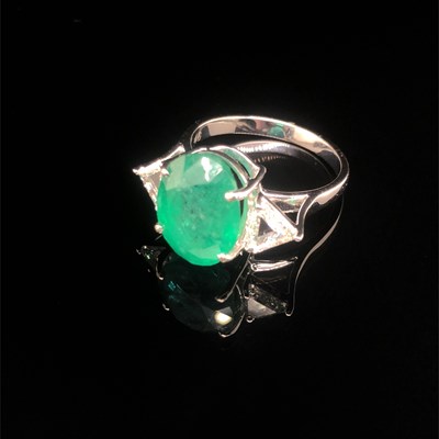 Lot 66 - An emerald and diamond ring. The central oval...