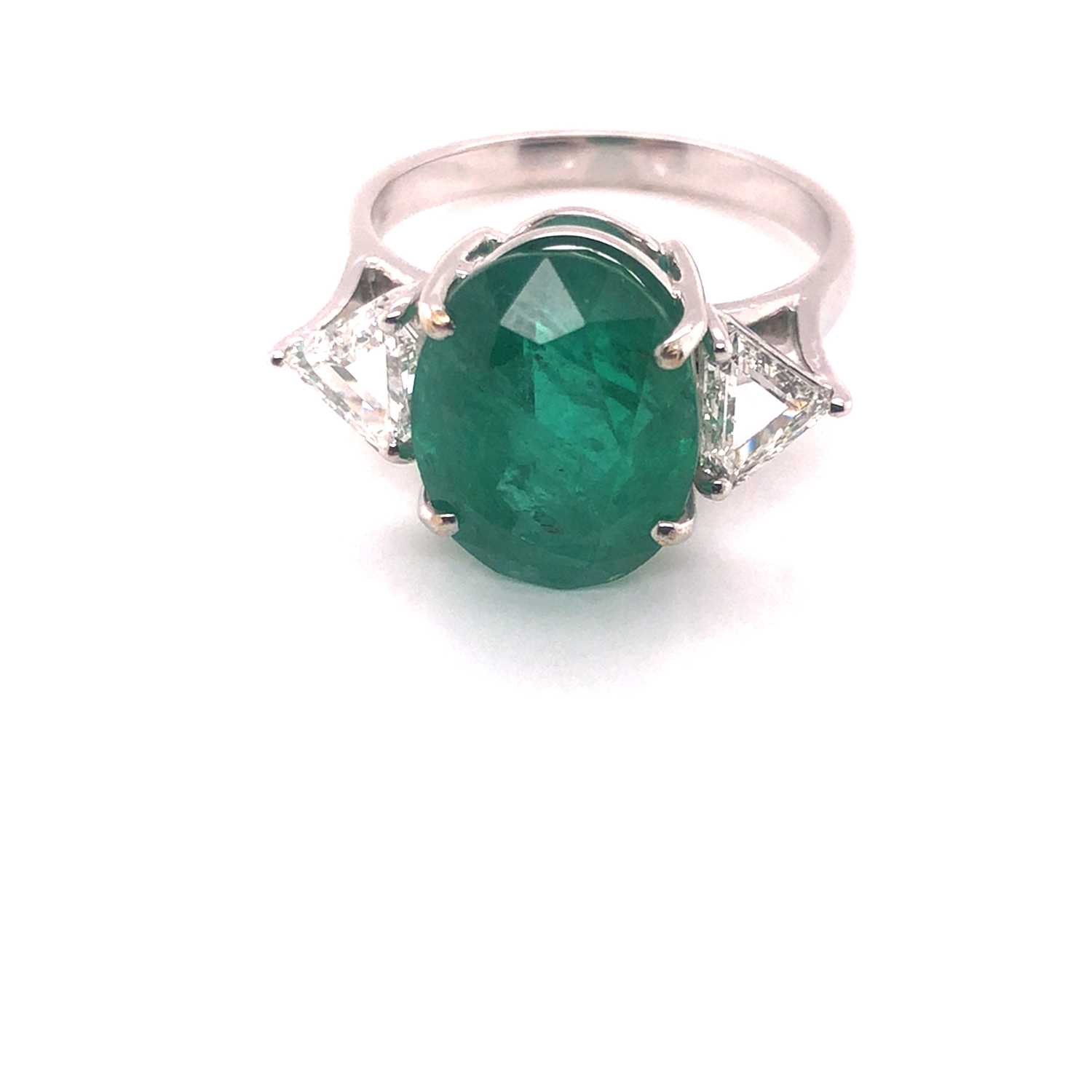 Lot 66 - An emerald and diamond ring. The central oval...