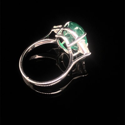 Lot 66 - An emerald and diamond ring. The central oval...
