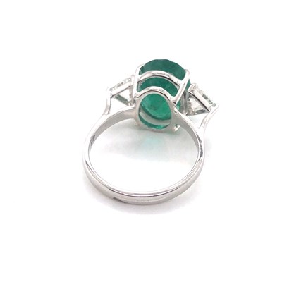 Lot 66 - An emerald and diamond ring. The central oval...