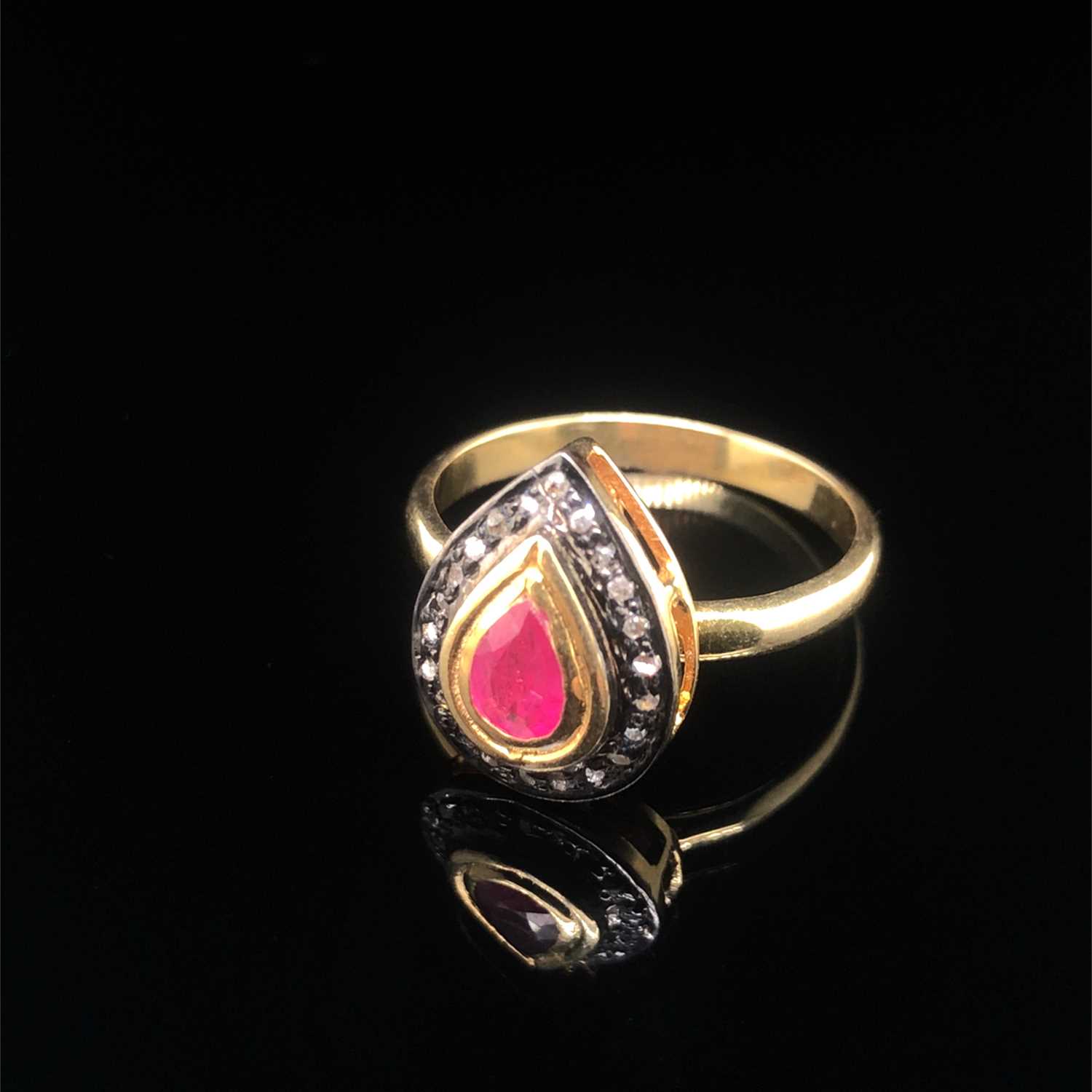 Lot 114 - A pear-shaped ring set with a pear-shaped ruby...