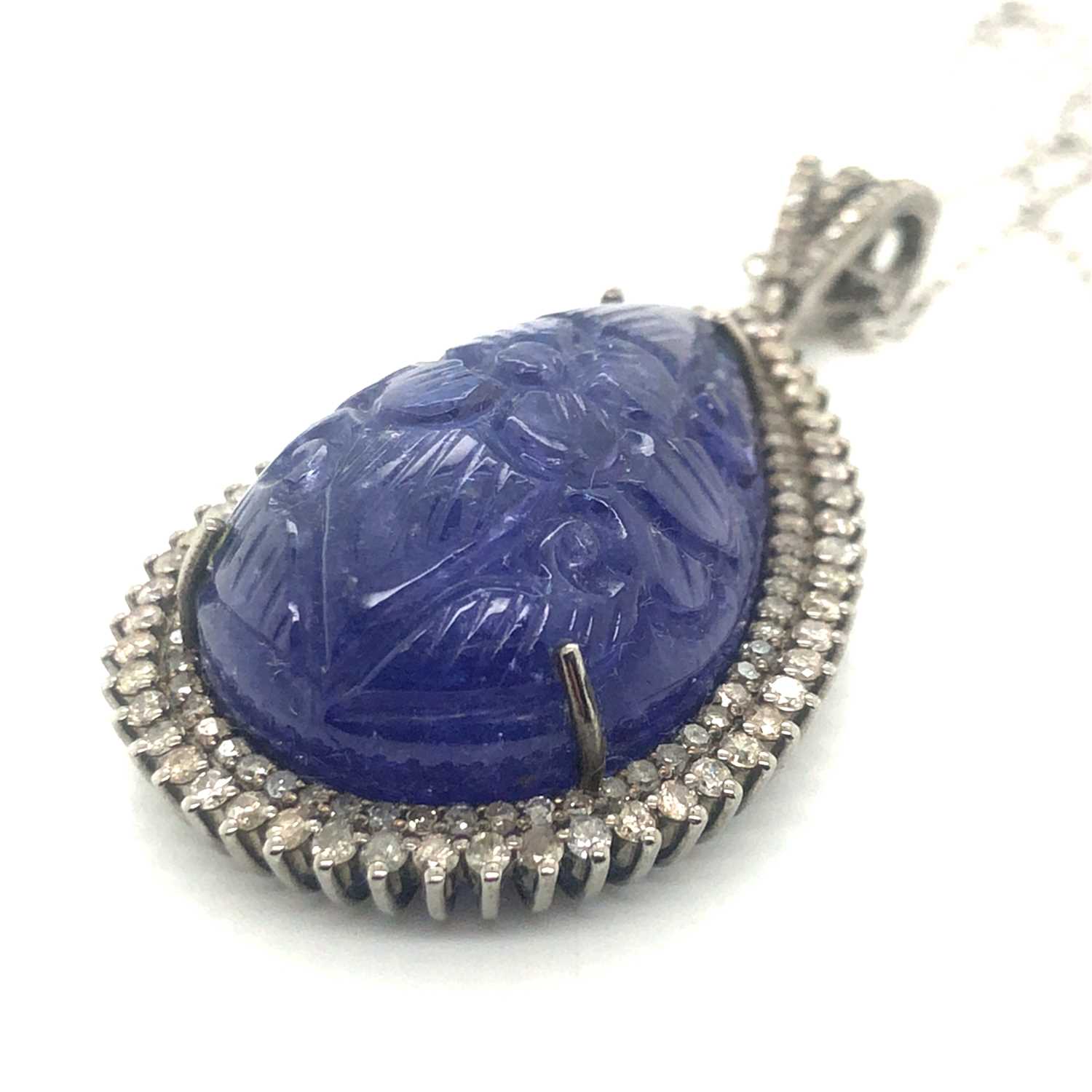 Lot 82 - A large pear-shaped carved tanzanite pendant...