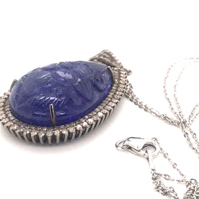 Lot 82 - A large pear-shaped carved tanzanite pendant...