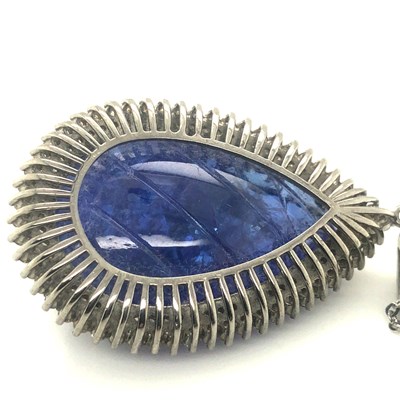 Lot 82 - A large pear-shaped carved tanzanite pendant...