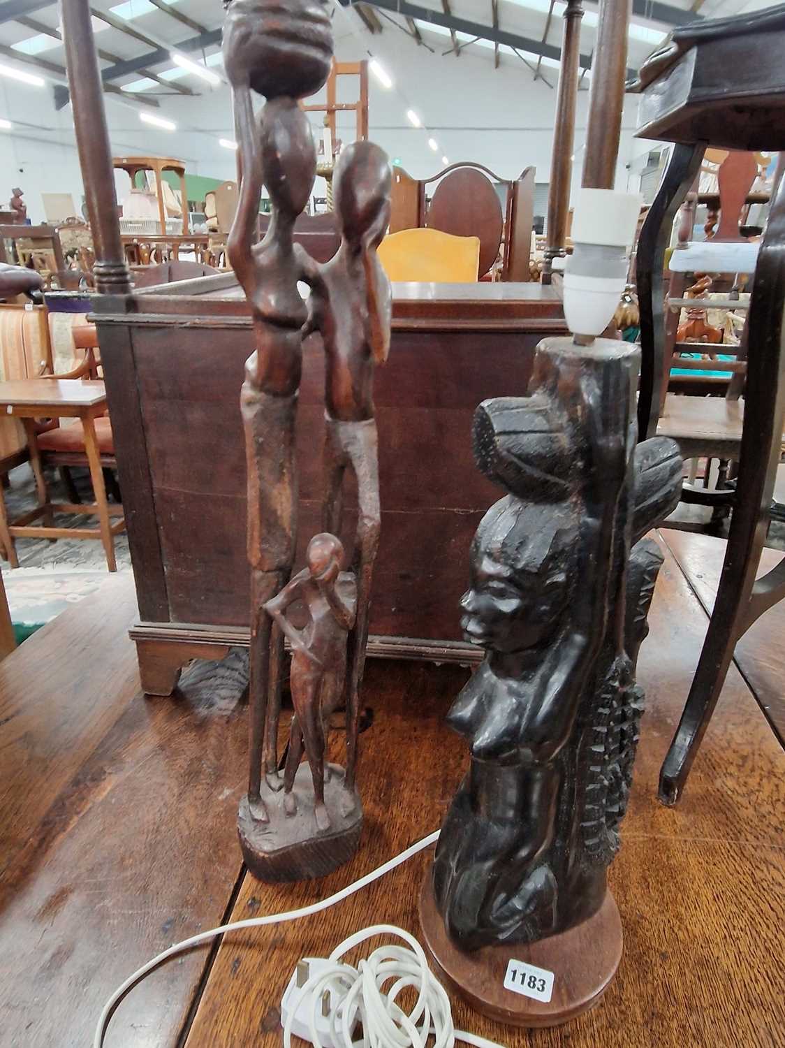 Lot 1183 - Two carved hardwood african figures together...