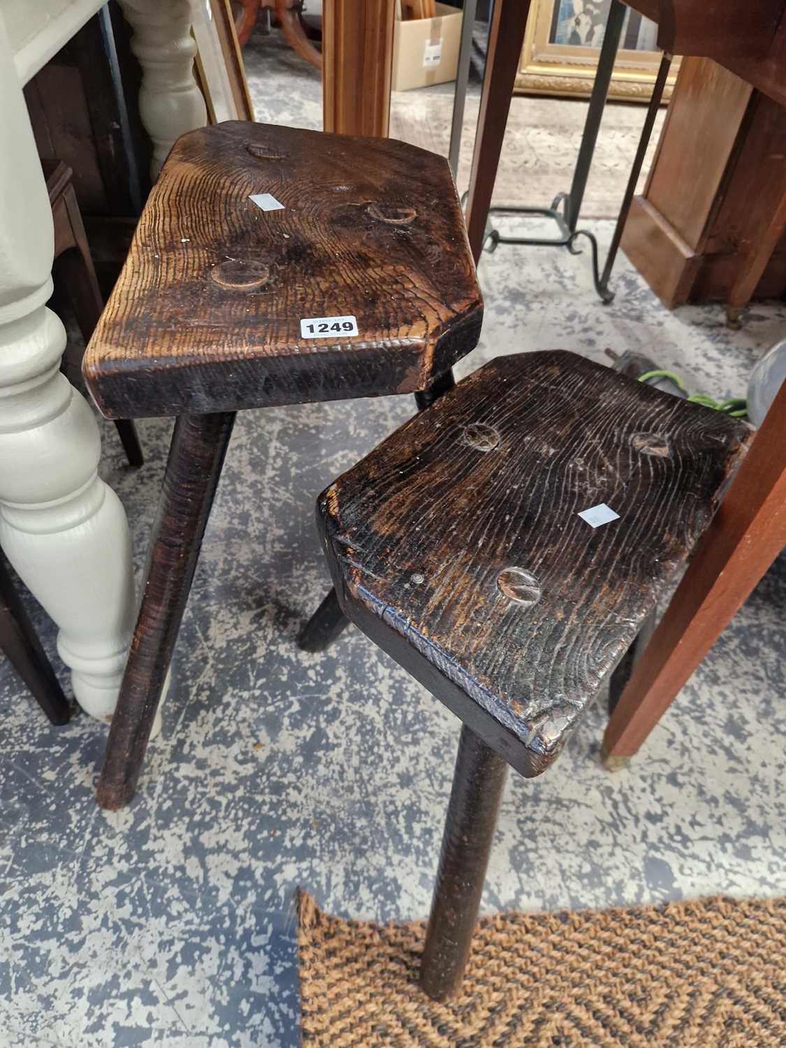 Lot 1249 - Two antique rustic milking stools.