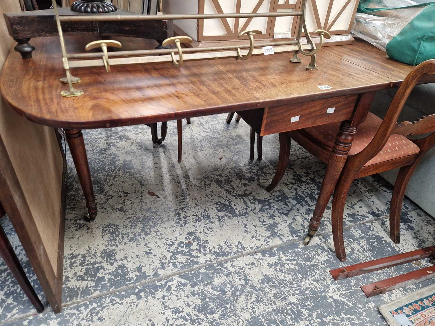 Lot 1296 - a 19th century drop leaf mahogany dining table.