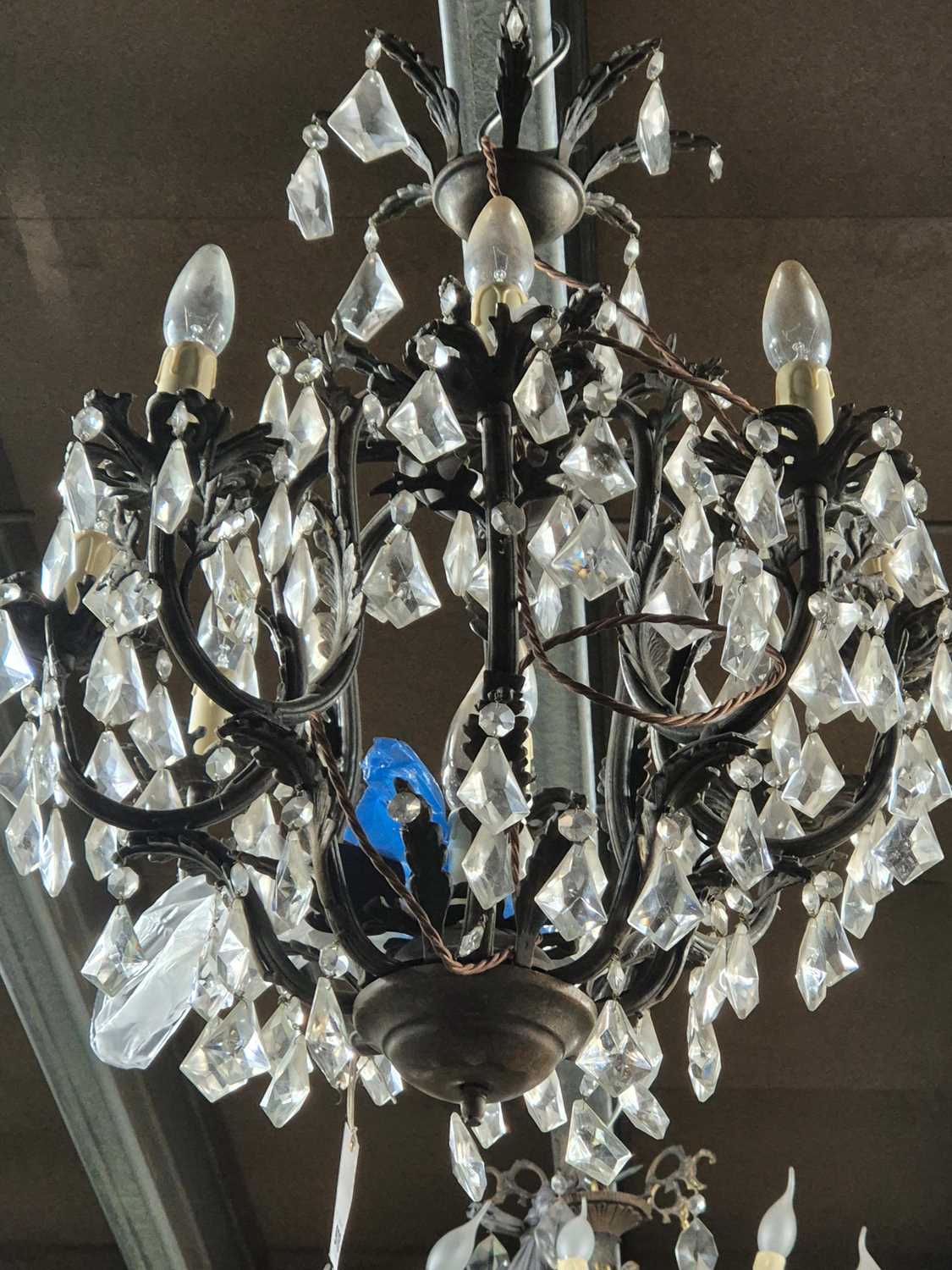 Lot 970 - A cast metal and glass nine light chandelier