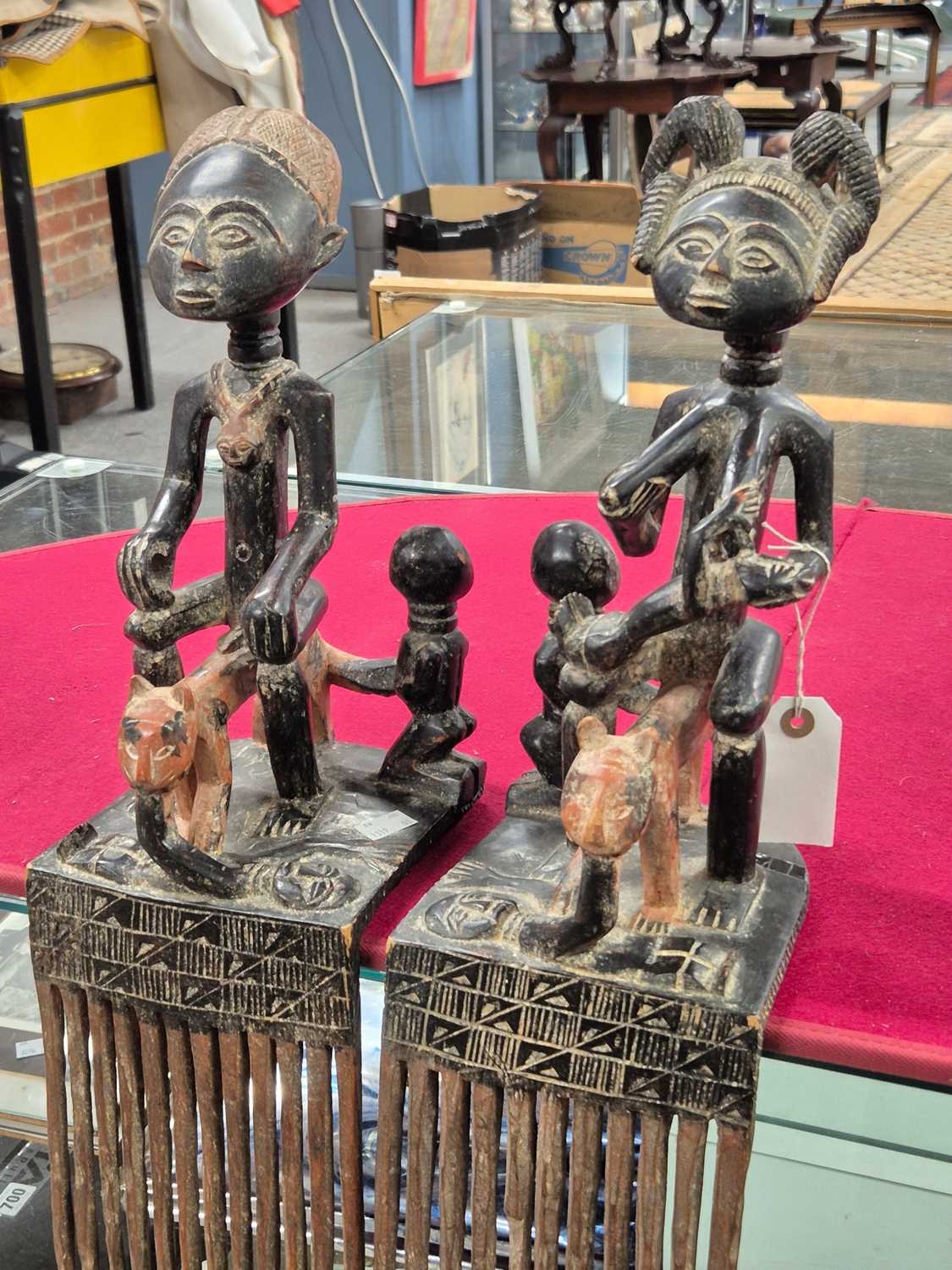 Lot 227 - A pair of African-carved wood figures on comb...