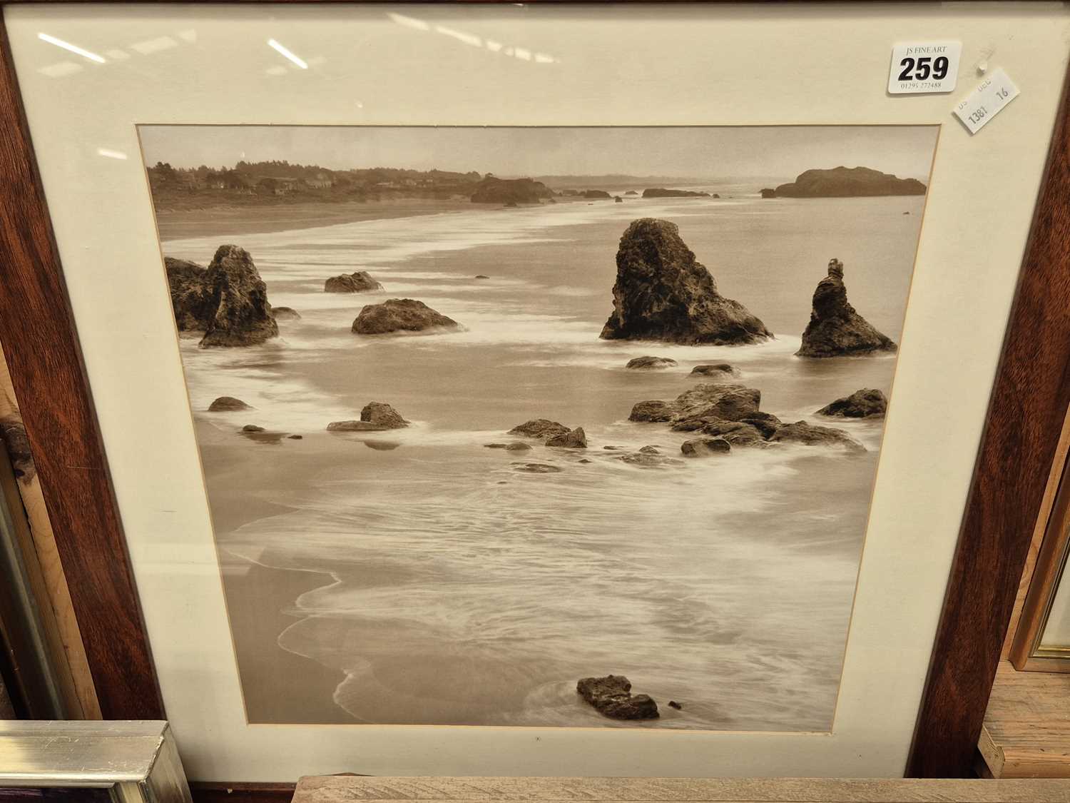 Lot 259 - A sepia tinted photograph of a shoreline and...