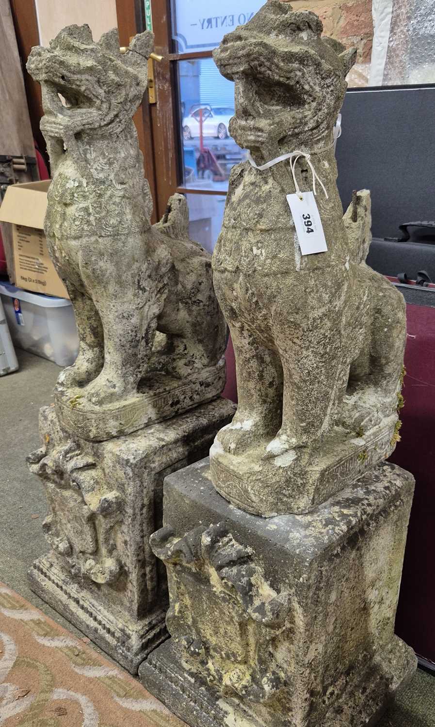 Lot 394 - A pair of reconstituted stone oriental lion...