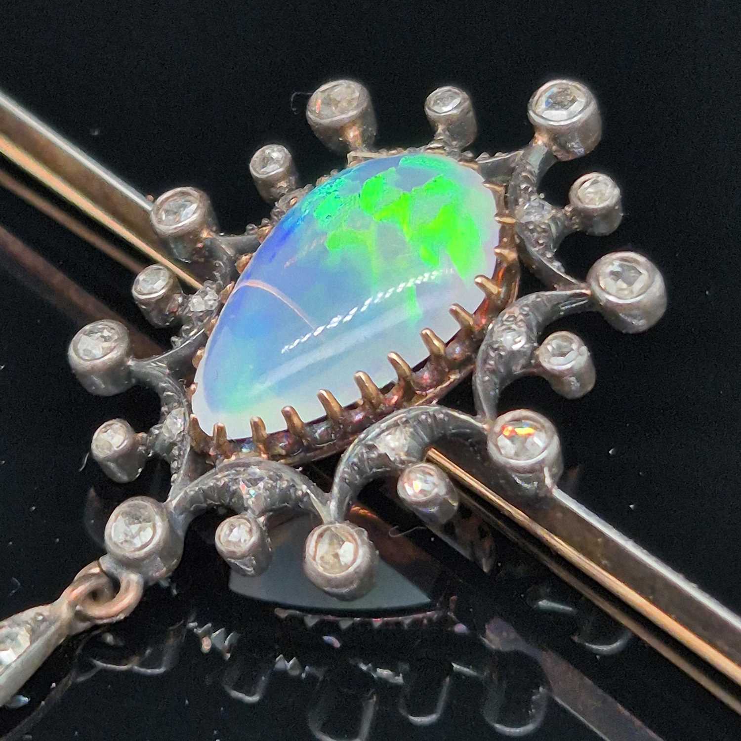 Lot 2 - An antique opal and diamond ornate bar brooch....