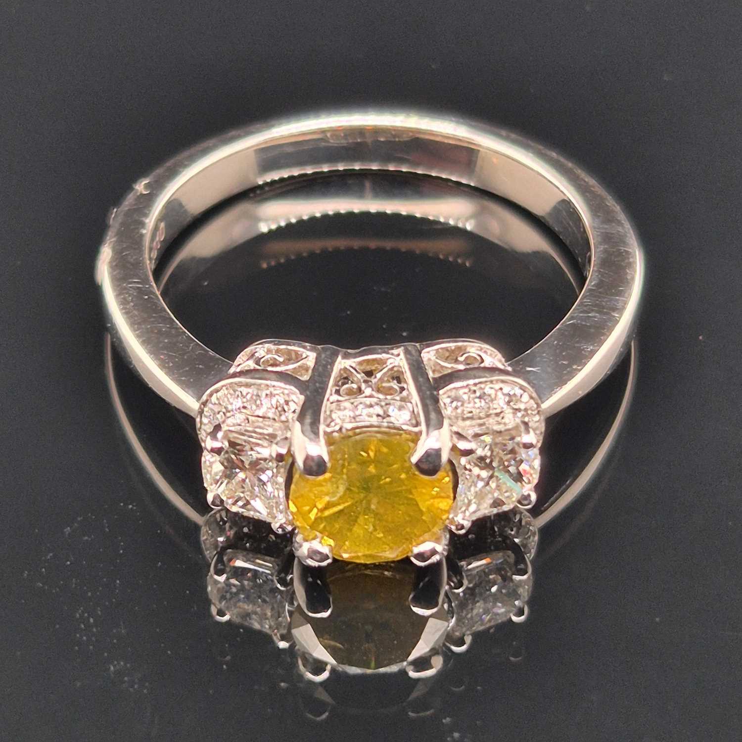 Lot 19 - A certificated fancy yellow diamond and...