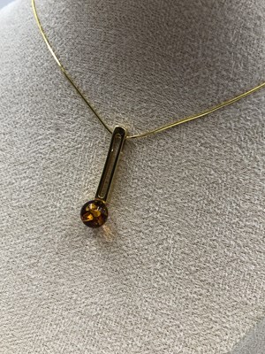 Lot 23 - A contemporary amber set pendant in a...