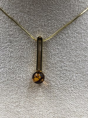 Lot 23 - A contemporary amber set pendant in a...
