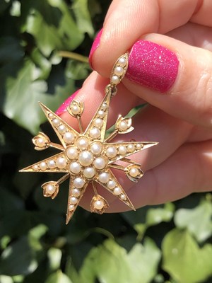 Lot 25 - An antique pearl set starburst pendant brooch...