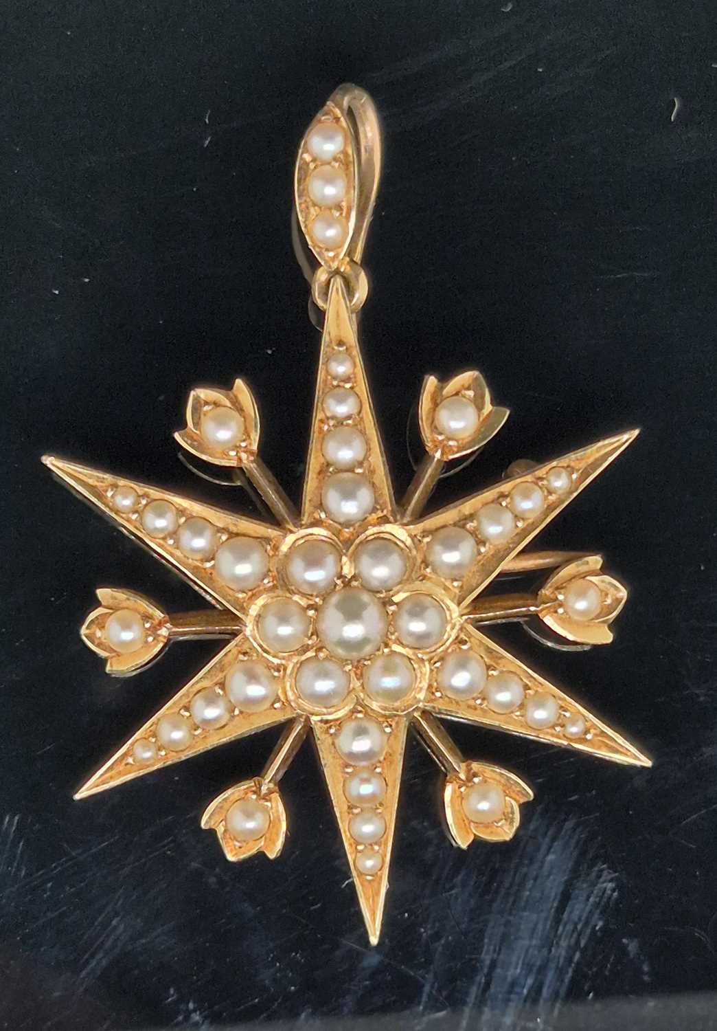 Lot 25 - An antique pearl set starburst pendant brooch...