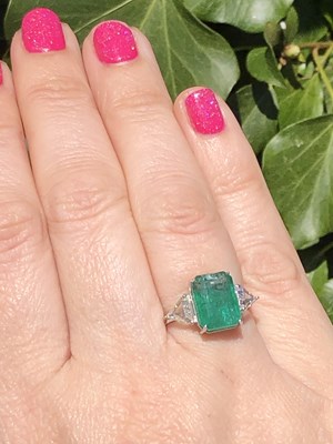 Lot 60 - An 18ct hallmarked white gold, emerald and...