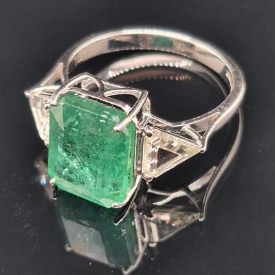 Lot 60 - An 18ct hallmarked white gold, emerald and...