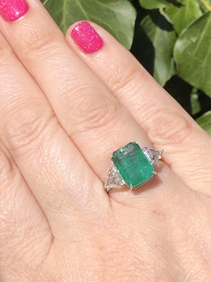 Lot 60 - An 18ct hallmarked white gold, emerald and...