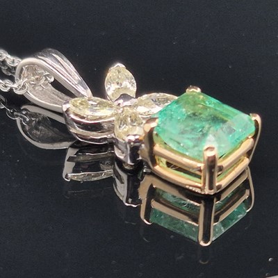 Lot 62 - An emerald and diamond pendant. The central...