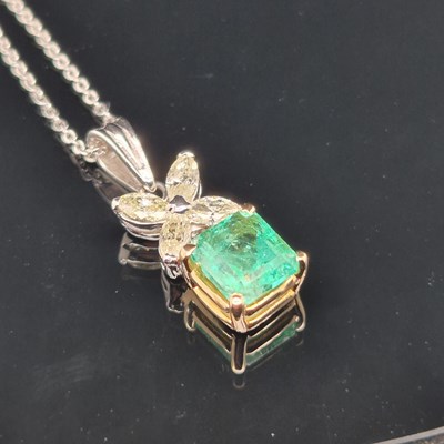 Lot 62 - An emerald and diamond pendant. The central...