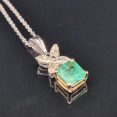 Lot 62 - An emerald and diamond pendant. The central...