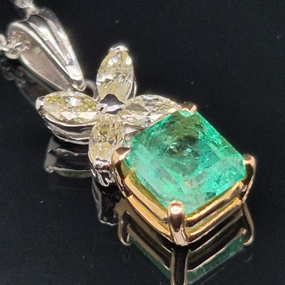 Lot 62 - An emerald and diamond pendant. The central...