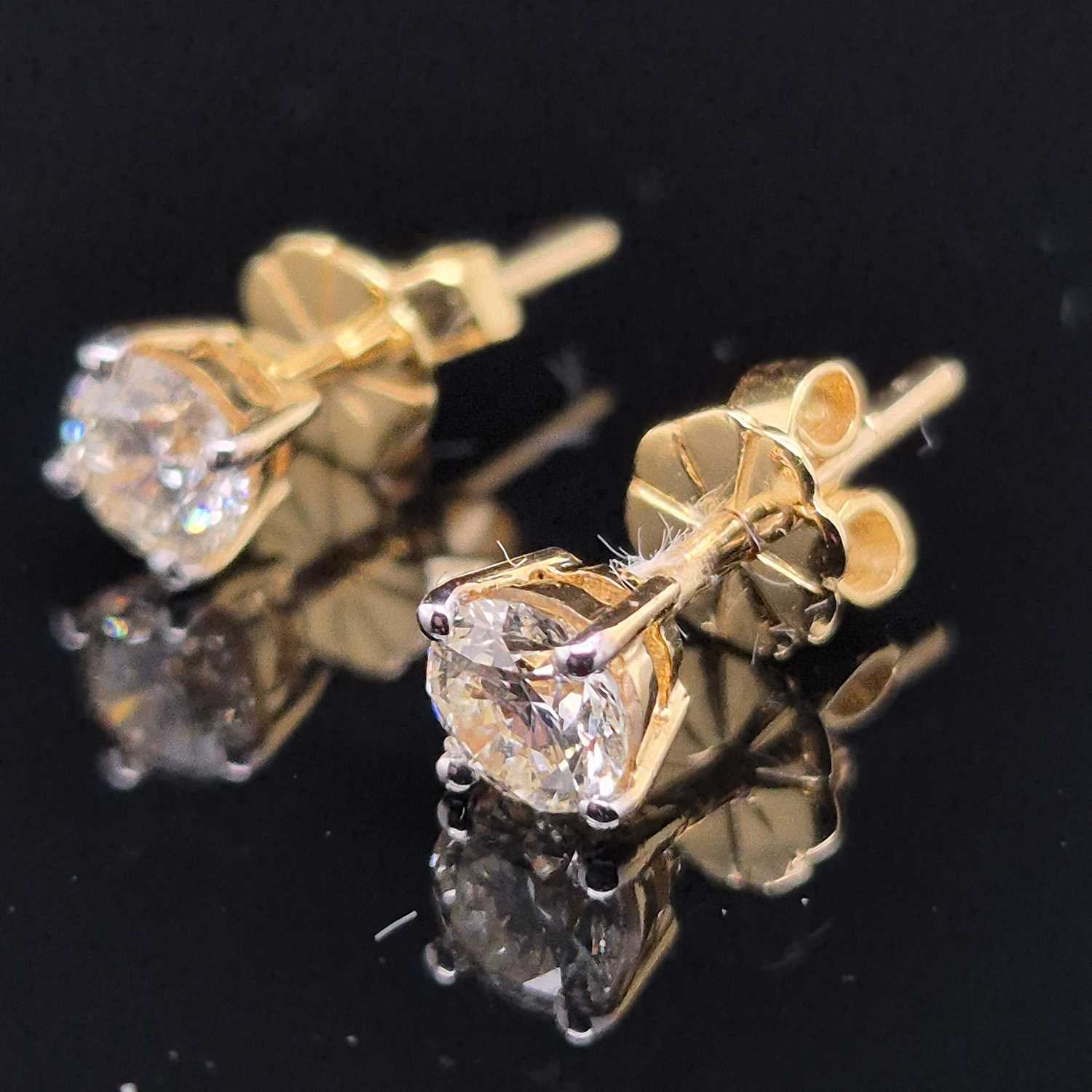 Lot 100 - A pair of round brilliant cut solitaire...