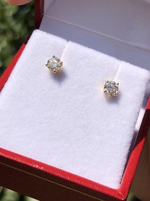 Lot 100 - A pair of round brilliant cut solitaire...