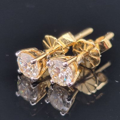 Lot 100 - A pair of round brilliant cut solitaire...
