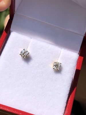 Lot 100 - A pair of round brilliant cut solitaire...