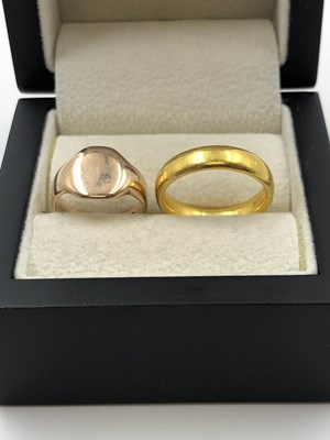 Lot 1047 - Two gold rings. A 22ct gold wedding ring, size...
