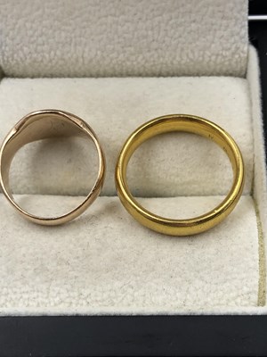 Lot 1047 - Two gold rings. A 22ct gold wedding ring, size...