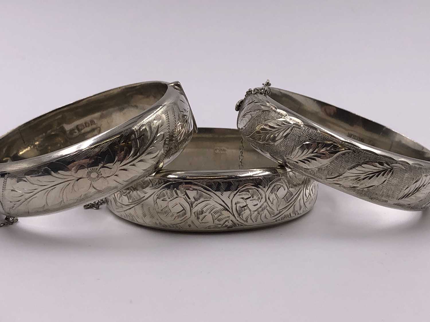 Lot 1037 - Three vintage hallmarked silver hinged bangles.