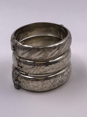 Lot 1037 - Three vintage hallmarked silver hinged bangles.