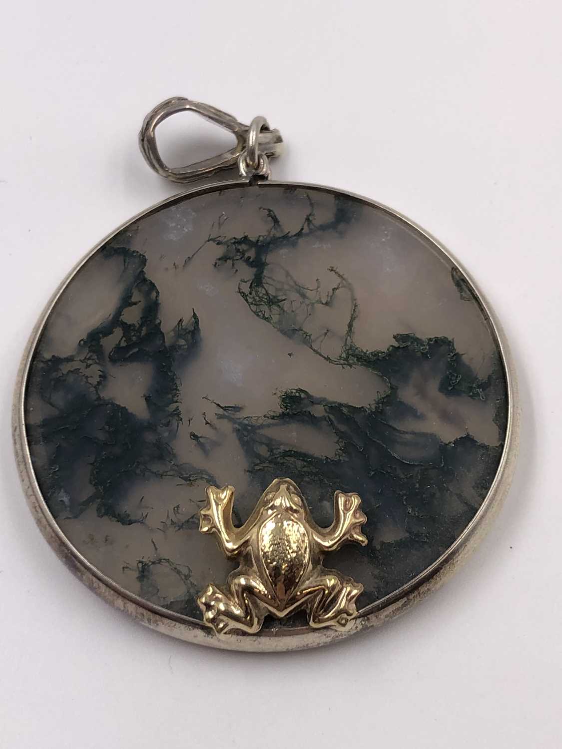 Lot 1020 - A moss agate gazing frog pendant in the style...