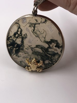 Lot 1020 - A moss agate gazing frog pendant in the style...