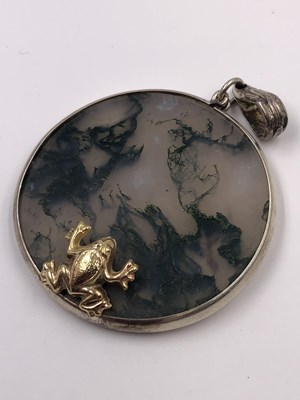 Lot 1020 - A moss agate gazing frog pendant in the style...