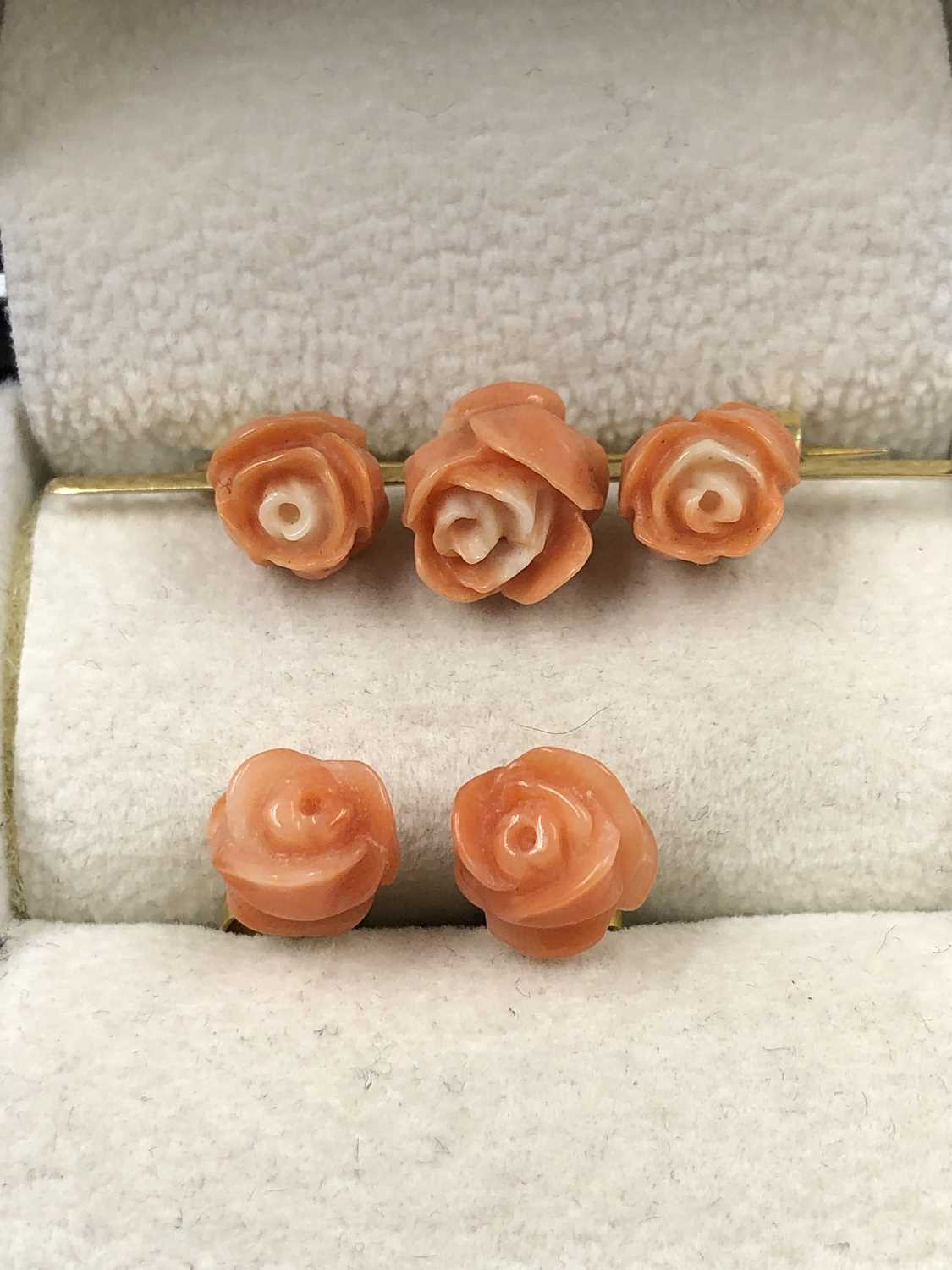 Lot 1019 - A vintage carved triple rose coral colour bar...