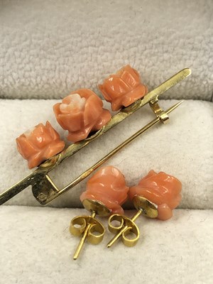 Lot 1019 - A vintage carved triple rose coral colour bar...