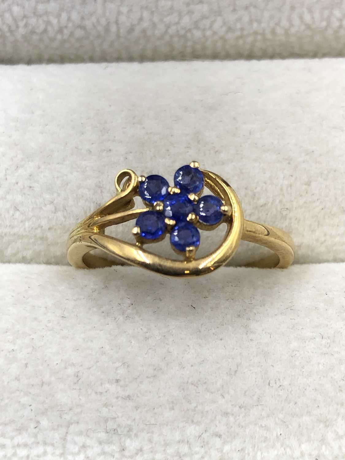 Lot 1029 - A blue gemset floral cluster ring, stamped 18c,...
